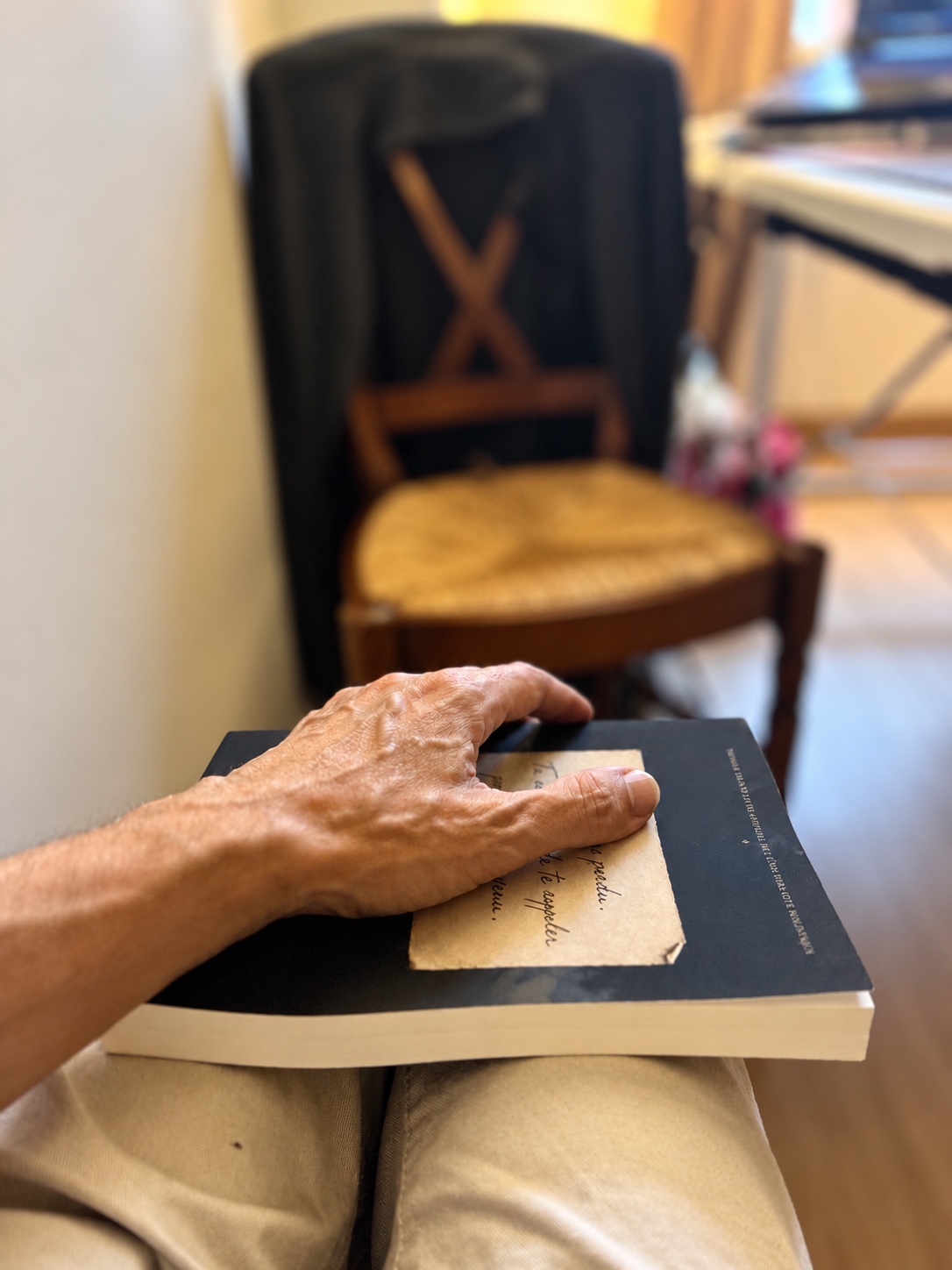 Une main posée sur le livre de Stéphane, ouvert à une conversation intime avec Élias.